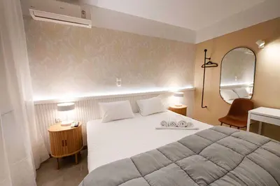 a bedroom with a large white bed and a mirror at LUX Hotel in Piraeus
