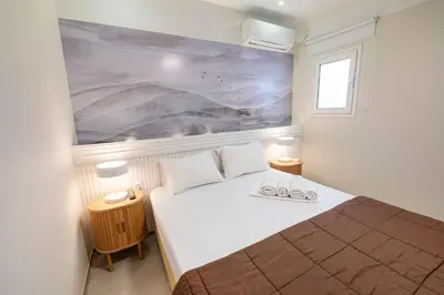 a bedroom with a bed with a painting on the wall at LUX Hotel in Piraeus
