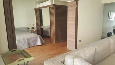 a bedroom with a bed and a couch and a mirror at Captains 2-Bedroom Suite in Athens Nea Smyrni in Athens