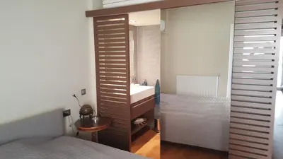 a bedroom with a bathroom with a sink and a mirror at Captains 2-Bedroom Suite in Athens Nea Smyrni in Athens