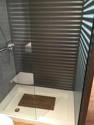 a shower with a glass door and a drain at Captains 2-Bedroom Suite in Athens Nea Smyrni in Athens