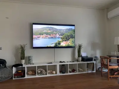 a flat screen tv on a wall in a living room at Captains 2-Bedroom Suite in Athens Nea Smyrni in Athens