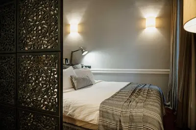 a bedroom with a bed and two lights on the wall at The Zillers Boutique Hotel in Athens