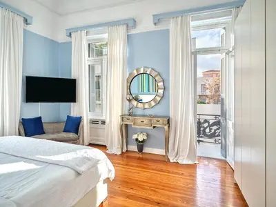 a bedroom with blue walls and a bed and a mirror at The White House in Plaka by JJ Hospitality in Athens