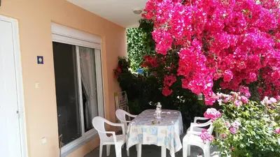 a table and chairs in a room with flowers at Markella's House in Vravrona