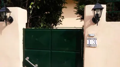 a green door with a sign and two lights at Markella's House in Vravrona