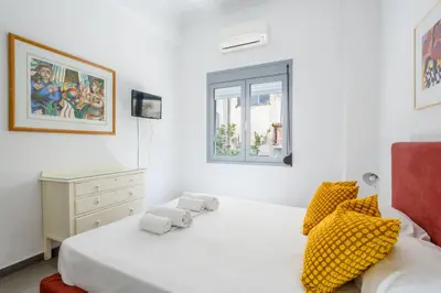 a white bedroom with two beds and a window at Renovated 4 Bdr House near Acropolis - New Beds, Terrace & Green Yard in Athens