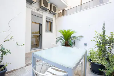a blue table in front of a white building with plants at Renovated 4 Bdr House near Acropolis - New Beds, Terrace & Green Yard in Athens
