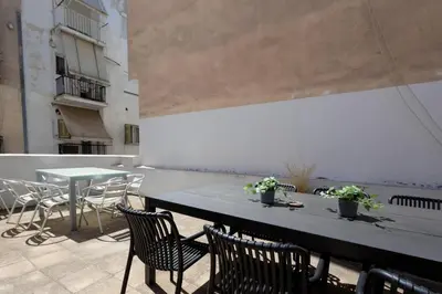 a patio with a table and chairs on a balcony at Renovated 4 Bdr House near Acropolis - New Beds, Terrace & Green Yard in Athens
