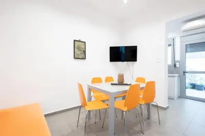 a dining room with a table and orange chairs at Renovated 4 Bdr House near Acropolis - New Beds, Terrace & Green Yard in Athens