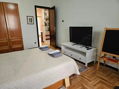 a bedroom with a bed and a flat screen tv at 3 bedder condo in Ilisia, Megaro Mousikis in Athens