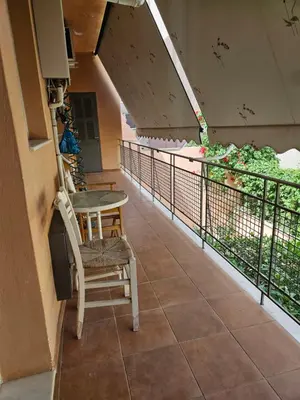 a porch with a chair and a table on a balcony at 3 bedder condo in Ilisia, Megaro Mousikis in Athens