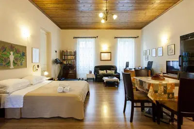 a bedroom with a bed and a living room at Psyri Neoclassical House Yard Free Parking in Athens