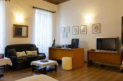 a living room with a couch and a tv at Psyri Neoclassical House Yard Free Parking in Athens