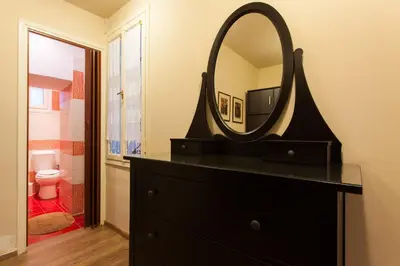 a bathroom with a black dresser and a mirror at Psyri Neoclassical House Yard Free Parking in Athens