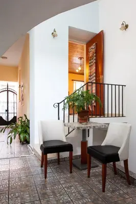 a hallway with two chairs and a table and a staircase at Psyri Neoclassical House Yard Free Parking in Athens