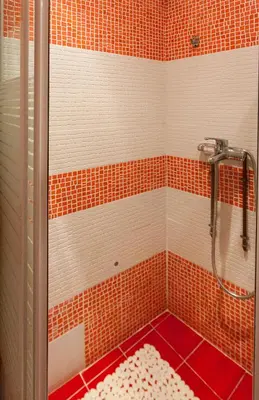 a shower with orange and white tiles in a bathroom at Psyri Neoclassical House Yard Free Parking in Athens