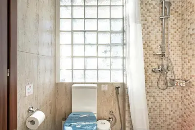 a bathroom with a toilet and a window and a shower at Explore Nightlife Near an Apartment With an Acropolis View in Athens