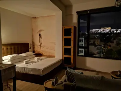 a bedroom with a bed and a large window at Explore Nightlife Near an Apartment With an Acropolis View in Athens