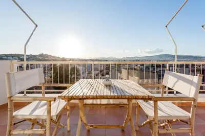 a wooden table and two chairs on a balcony at Explore Nightlife Near an Apartment With an Acropolis View in Athens