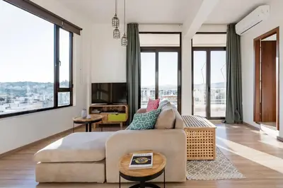 a living room with a couch and large windows at Explore Nightlife Near an Apartment With an Acropolis View in Athens