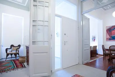 a room with white doors and a table and chairs at Neoclassical House at Metro Station Attiki in Athens