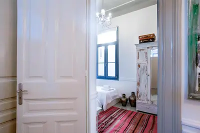 a white door in a room with a red rug at Neoclassical House at Metro Station Attiki in Athens