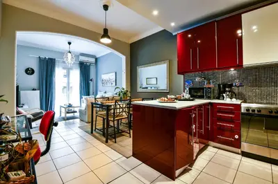 a kitchen with red cabinets and a living room at Star Acropolis Apartment in Athens
