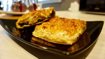 two pies on a black plate on a table at Star Acropolis Apartment in Athens