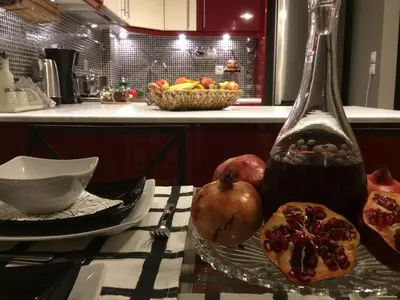 a table with a bowl of fruit and a bottle at Star Acropolis Apartment in Athens