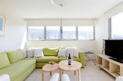 a living room with a green couch and a tv at GB Athens View Luxury Suite in Athens