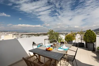a table on a balcony with a view of the city at GB Athens View Luxury Suite in Athens