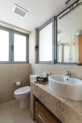 a bathroom with a sink and a toilet and windows at GB Athens View Luxury Suite in Athens