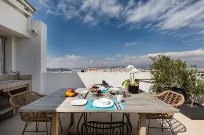 a wooden table on the balcony of a house at GB Athens View Luxury Suite in Athens