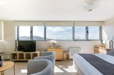a bedroom with a bed and a tv and some windows at GB Athens View Luxury Suite in Athens