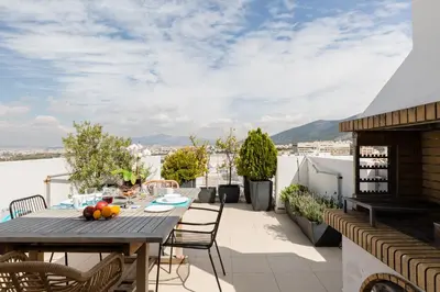 a patio with a table and chairs on a balcony at GB Athens View Luxury Suite in Athens