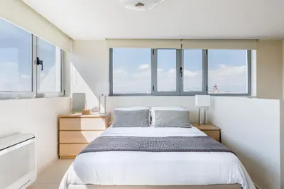a bedroom with a large bed and windows at GB Athens View Luxury Suite in Athens