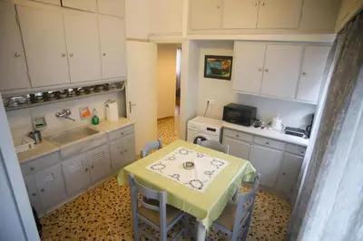 a small kitchen with a table and a sink at Mairas house collection in Athens