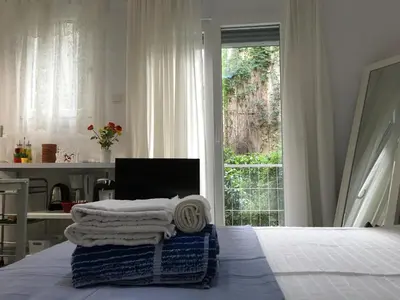 a bedroom with a bed with a desk and a window at Newly Renovated Apt in Kolonaki in Athens