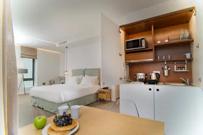 a room with a bed and a kitchen with a table at NLH FIX | Neighborhood Lifestyle Hotels in Athens