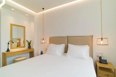 a bedroom with a large bed and a mirror at NLH FIX | Neighborhood Lifestyle Hotels in Athens