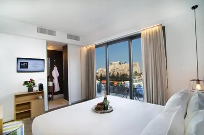 a bedroom with a large white bed and a large window at NLH FIX | Neighborhood Lifestyle Hotels in Athens