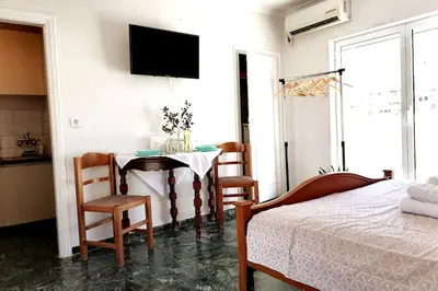 a bedroom with a table and chairs and a bed at Acropolis Area Flat with Parthenon Views in Athens