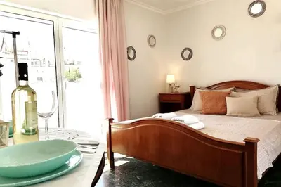 a bedroom with a bed and a bottle of wine at Acropolis Area Flat with Parthenon Views in Athens