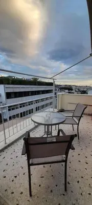 a patio with two chairs and a table on a balcony at Acropolis Area Flat with Parthenon Views in Athens