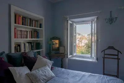 a room with a bed and a window with books at Acropolis Villa in Plaka in Athens