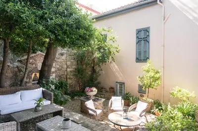 an outdoor patio with a table and chairs at Acropolis Villa in Plaka in Athens