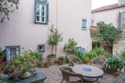 a patio with a table and chairs and potted plants at Acropolis Villa in Plaka in Athens