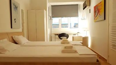 two beds in a room with a window at Errathens Apartments - Athens Center in Athens