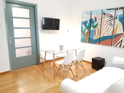 a dining room with a table and chairs and a tv at Errathens Apartments - Athens Center in Athens